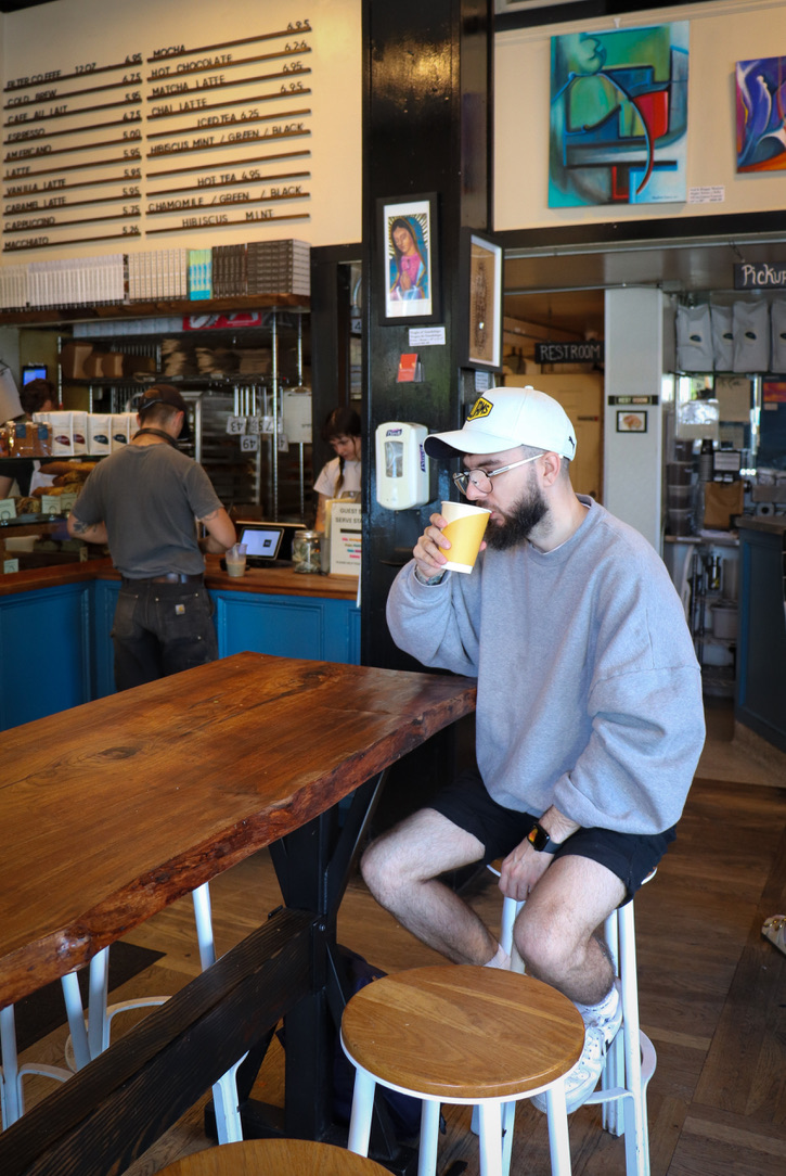 Pete drinking coffee in a café